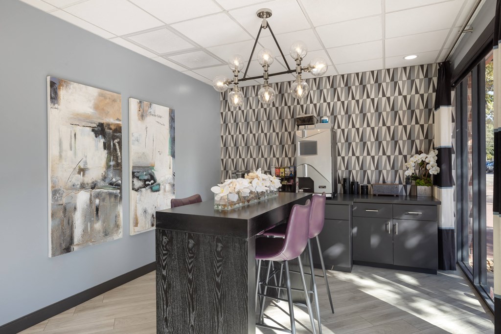 a kitchen with a bar and chairs and a painting on the wall