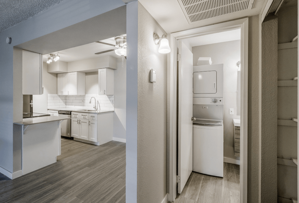 upgraded countertops and white cabinets with hardwood flooring