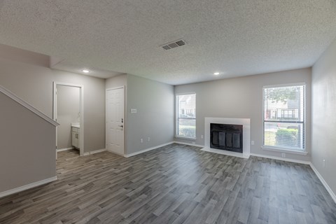 A living room with a fireplace and wood flooring.