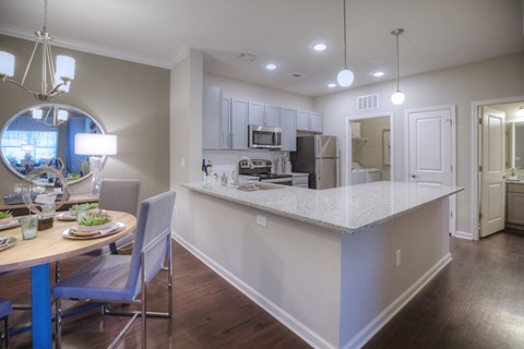 a kitchen and dining area with a white counter top