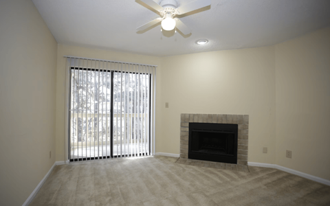 A room with a fireplace and a ceiling fan.