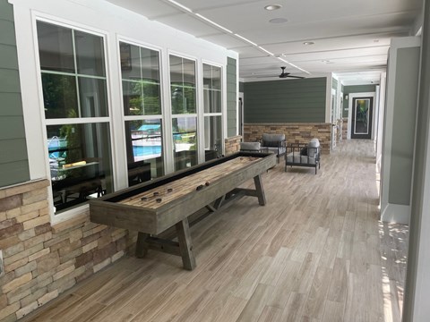 a large porch with a shuffleboard table in the front of a house