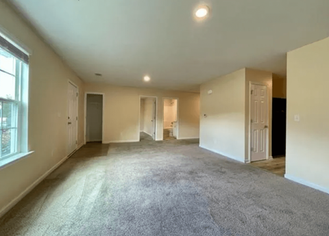 an empty living room with white walls and a carpet floor