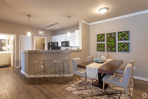 A modern kitchen with a dining table set for two.