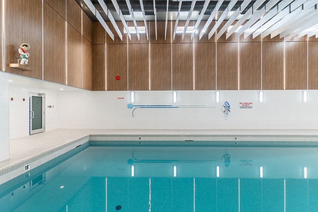 a large indoor swimming pool with white walls and wood paneling