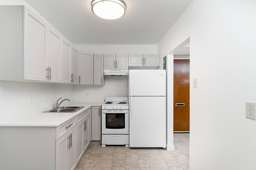 a kitchen with white cabinets and white appliances