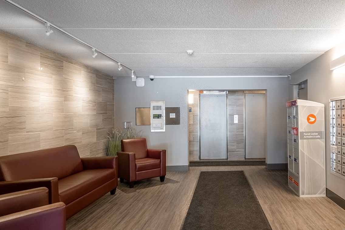 a lobby with couches and chairs and a glass door