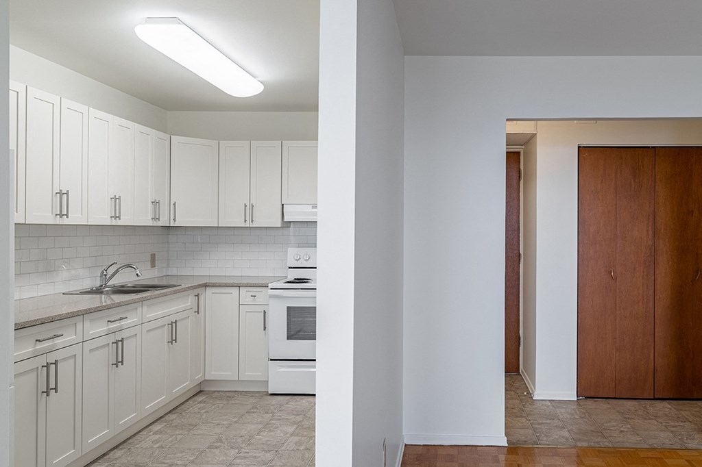 a kitchen with white cabinets and a white stove top oven