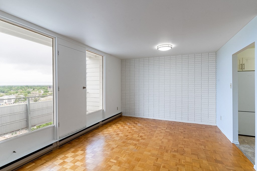 a bedroom with a large window and a wooden floor