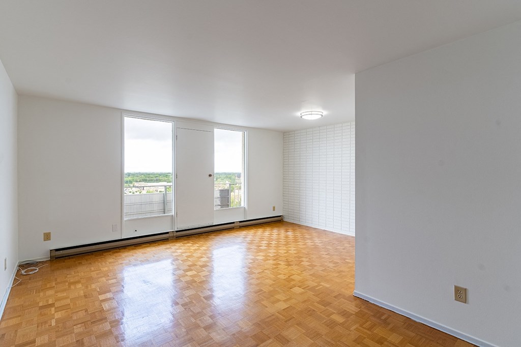 a bedroom with hardwood floors and white walls