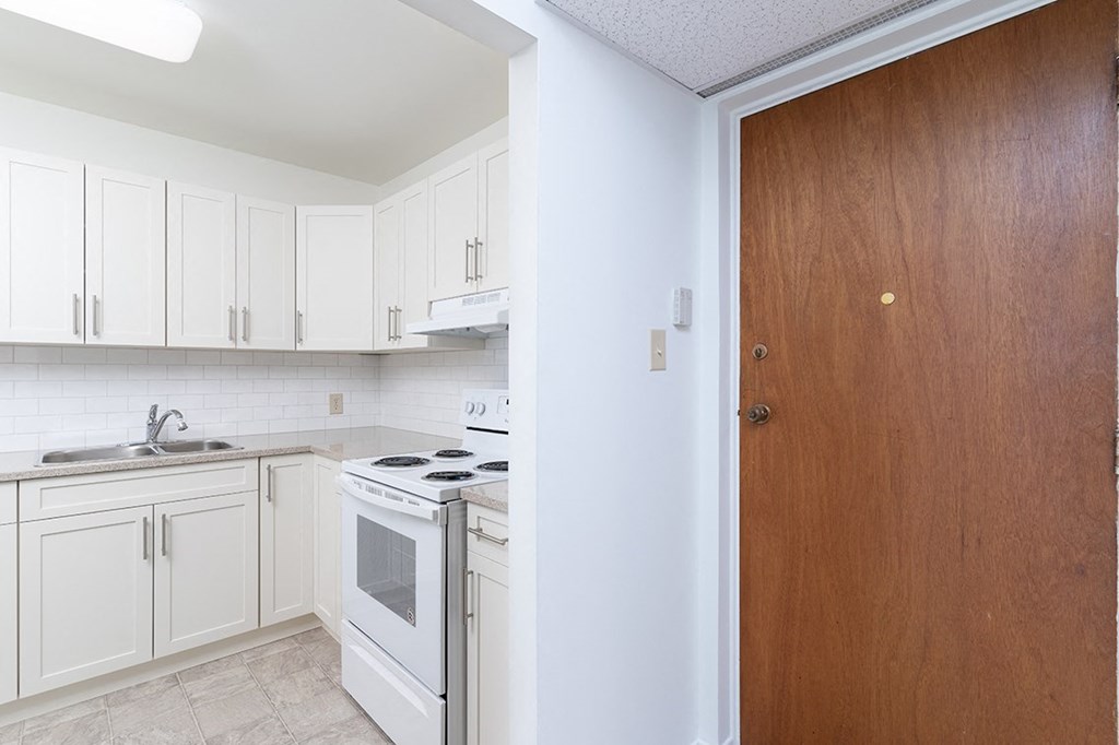 a kitchen with white cabinets and white appliances