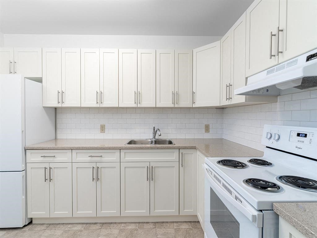 a white kitchen with white appliances and white cabinets