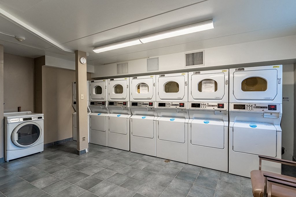 a laundry room with white washers and dryers