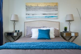 a bedroom with a bed with a blue blanket and pillows