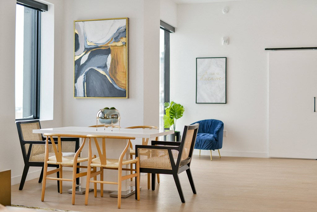 a dining room with a table and chairs and a painting on the wall