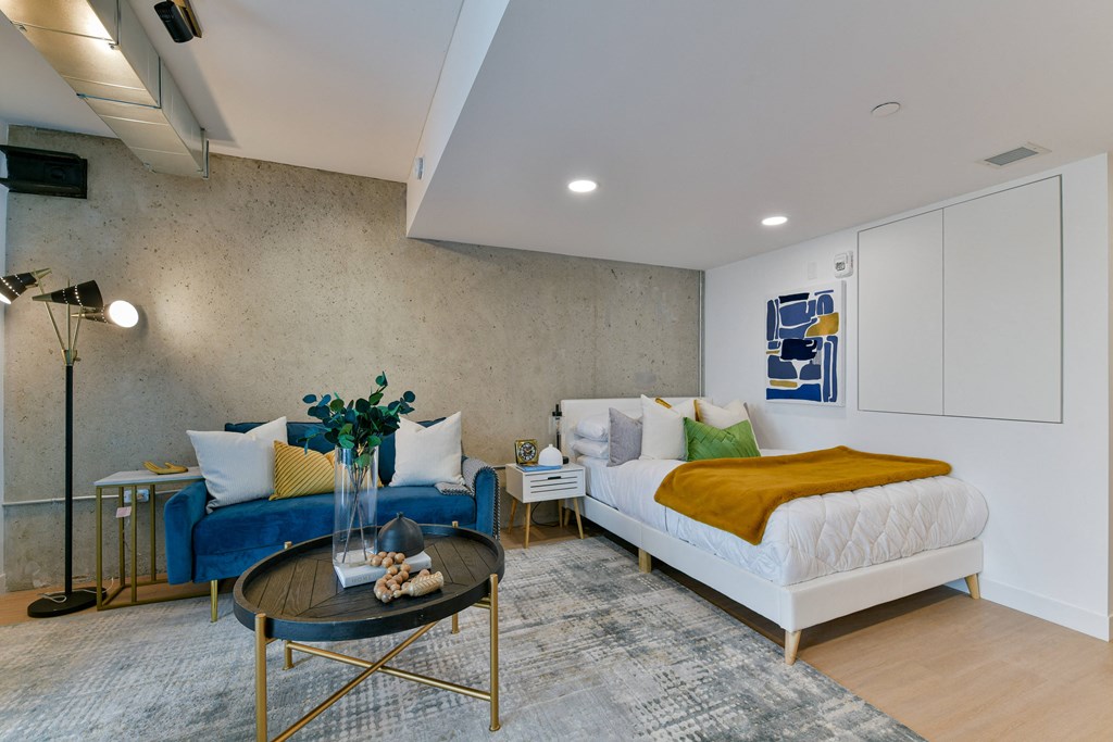 a bedroom with a bed and a couch and a table