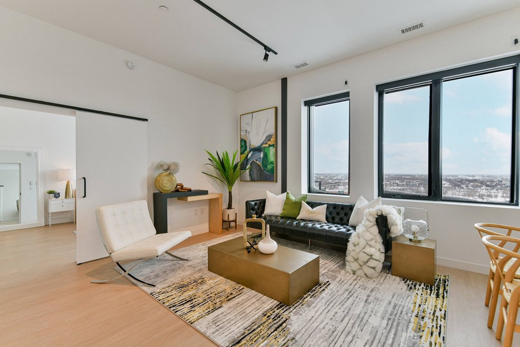 an open living room with a couch and a chair and a view of the city