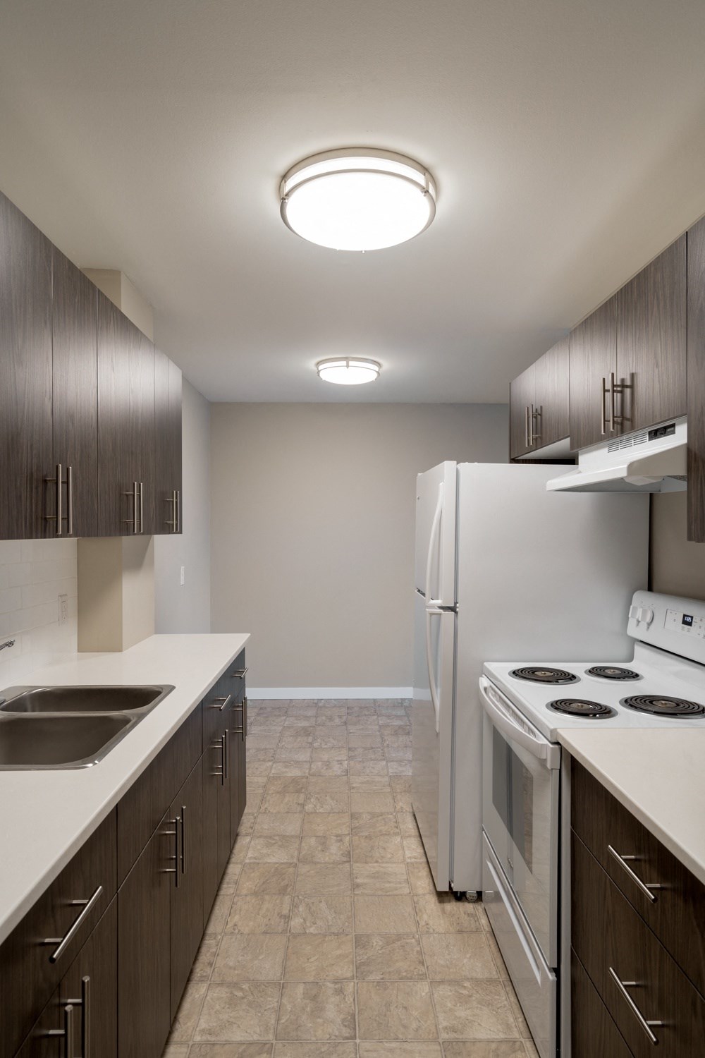 a kitchen with dark cabinets and white appliances