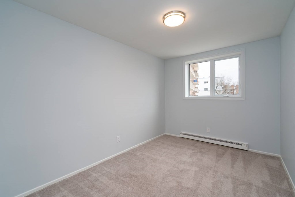 a bedroom with gray walls and a small window