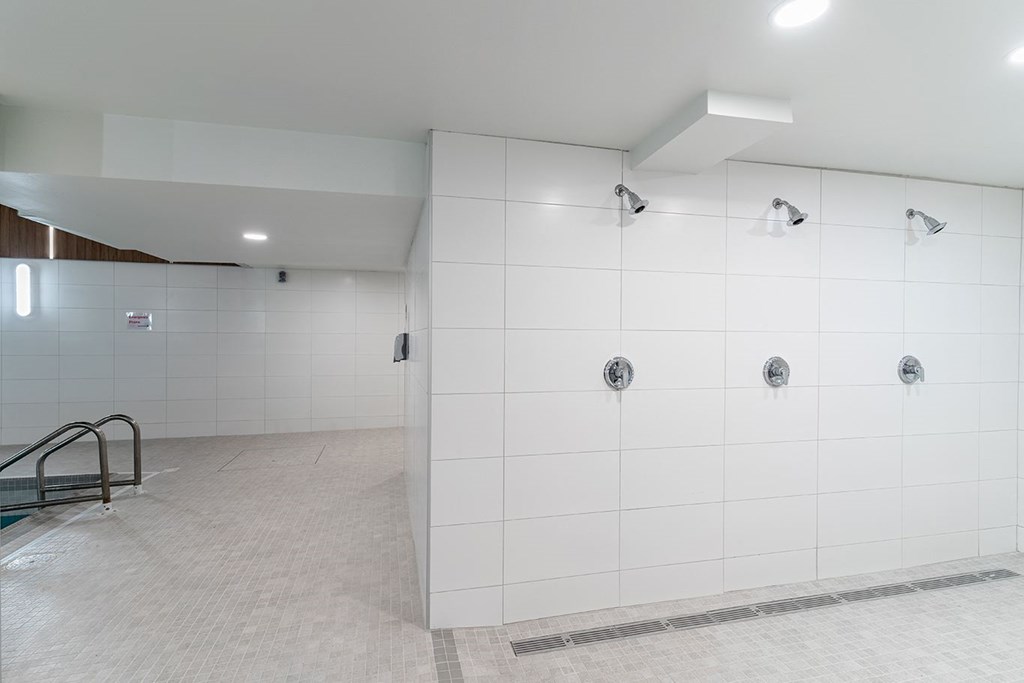a large white shower in a bathroom with a tiled floor