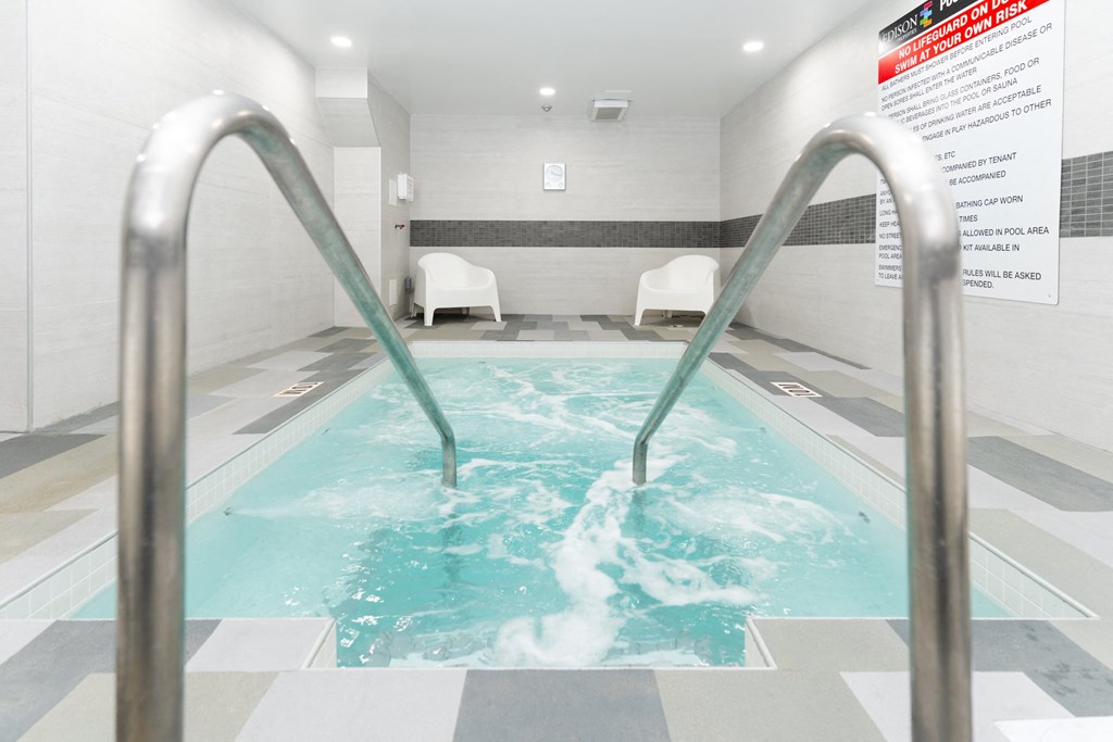 an indoor pool with two metal railings in the water