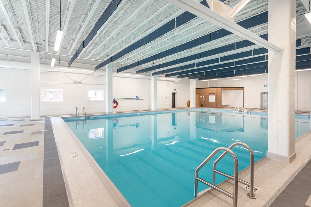 a large indoor swimming pool with white walls and ceilings