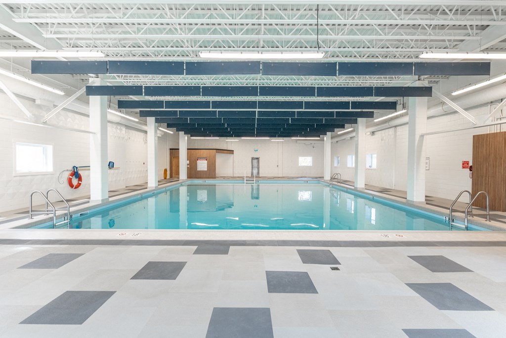 a large indoor swimming pool with white walls and ceilings and a checkered floor