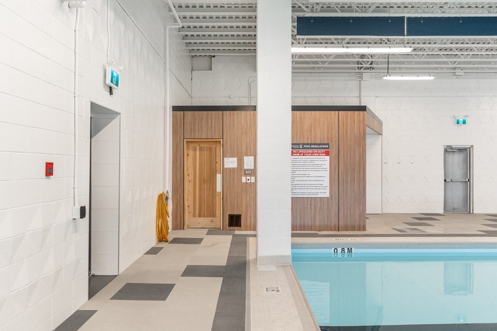 a swimming pool with a wooden door and a white wall with a sign on it