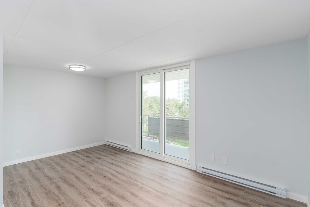 a bedroom with hardwood floors and white walls