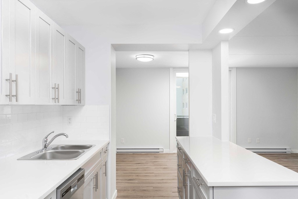 a kitchen with white countertops and stainless steel appliances