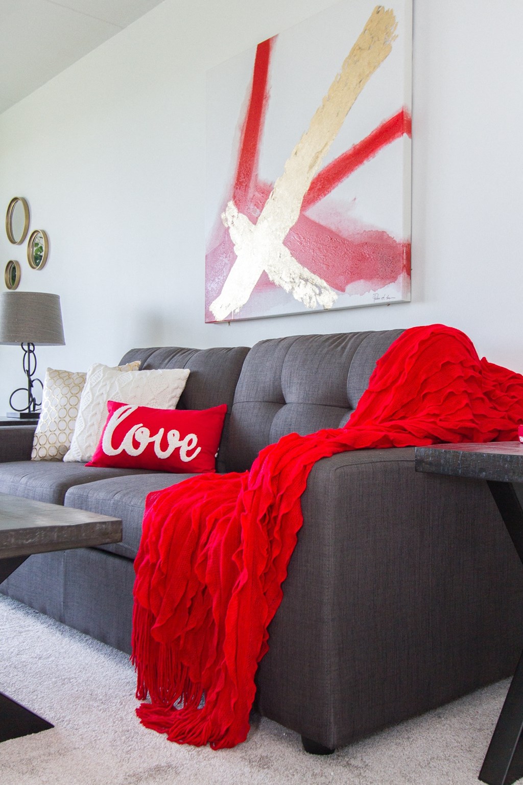 a couch with a red blanket and pillows on it