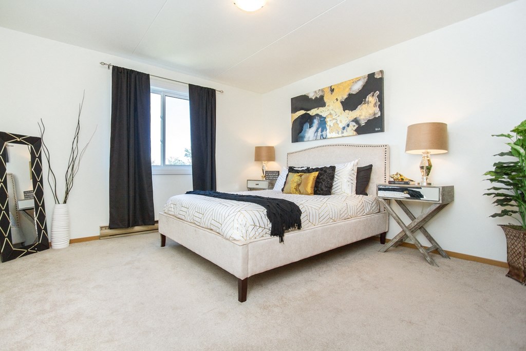 a bedroom with white walls and a beige carpet