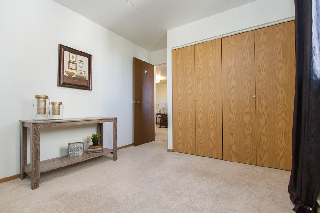 a bedroom with a wardrobe and a table with candles on it