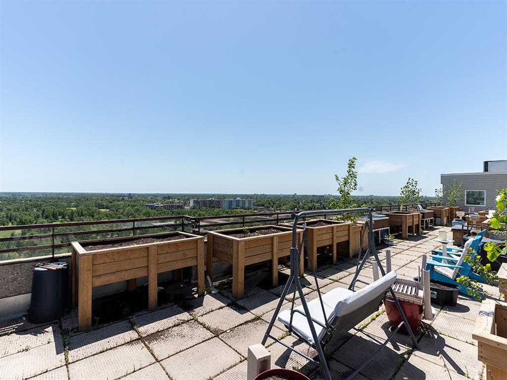 a rooftop terrace with tables and chairs on top of a building
