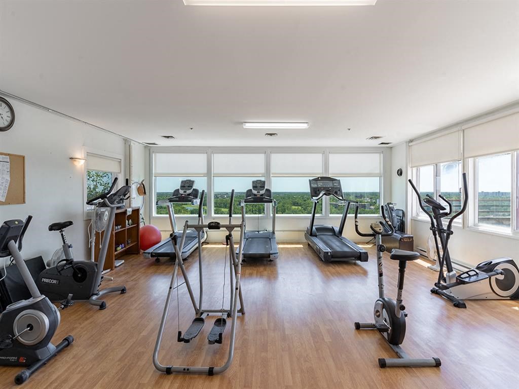 a gym with plenty of exercise equipment and windows