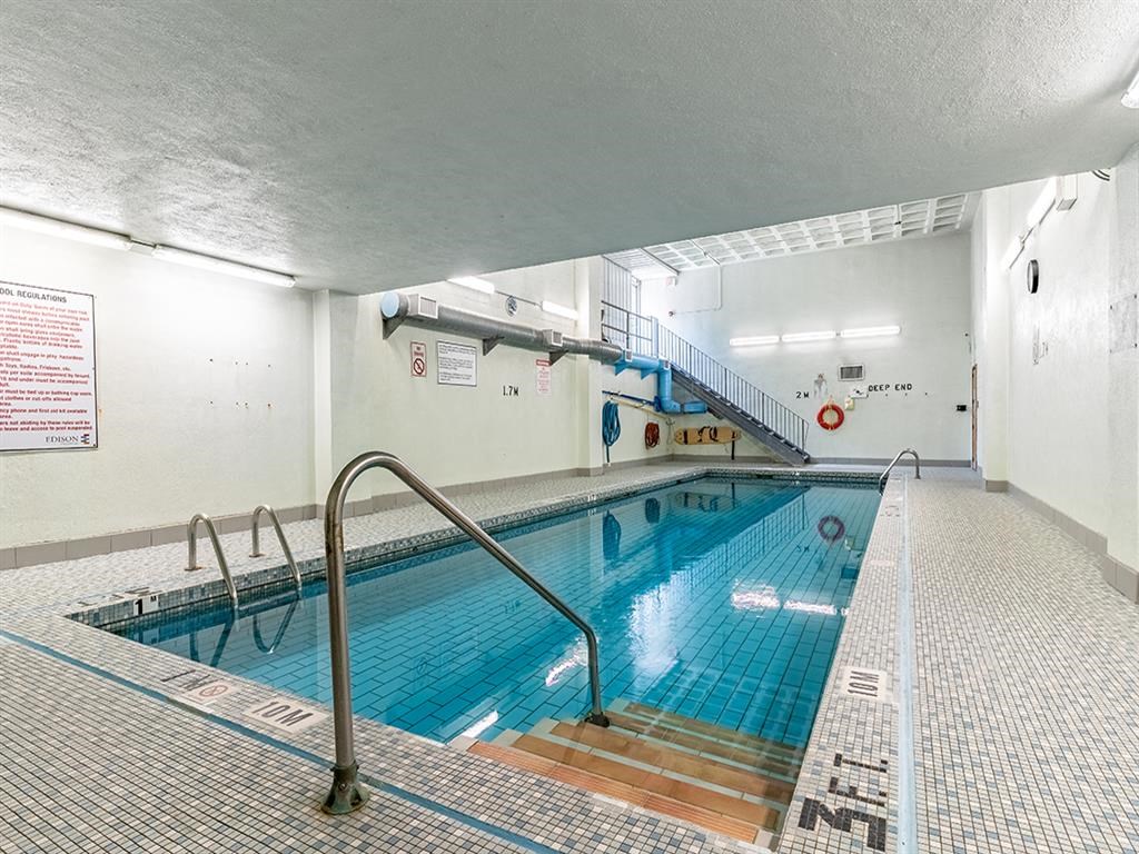 a swimming pool in a building with a staircase and a pool