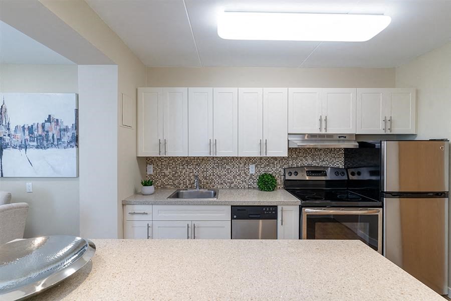 a kitchen with white cabinets and a counter top