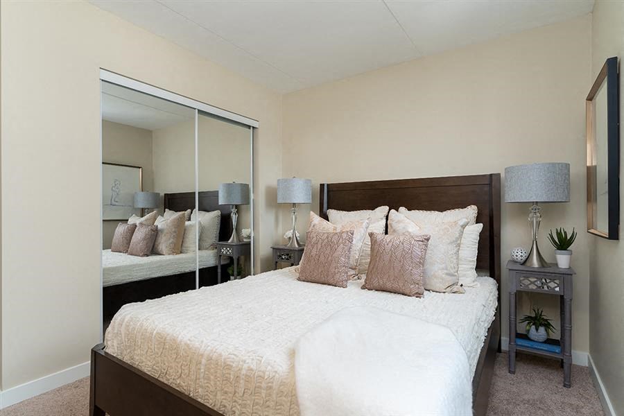 a bedroom with a large bed and a mirror