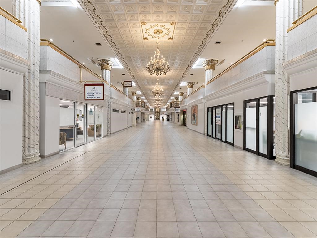 a long corridor in a building with a chandelier