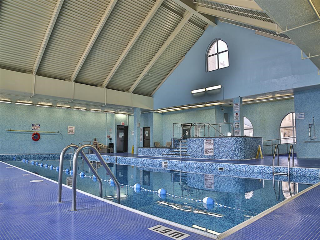 a swimming pool in a building with blue tiles