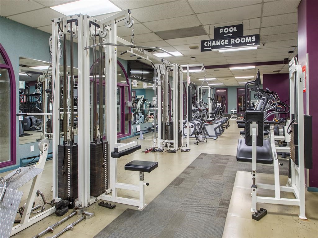 a gym with various machines and weights in it