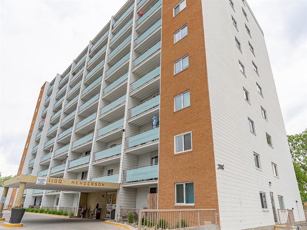 a tall apartment building with a street in front of it