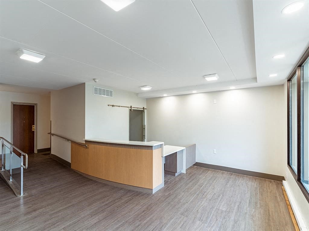 an empty room with a reception desk and a window