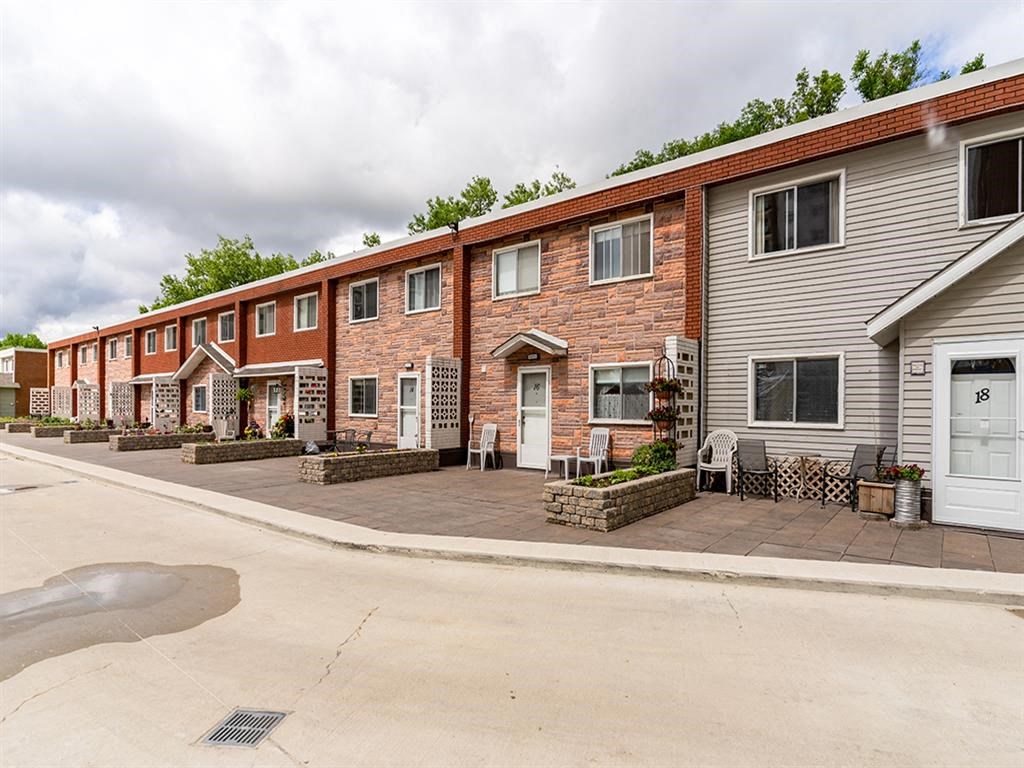 a row of brick apartment buildings on the side of a street