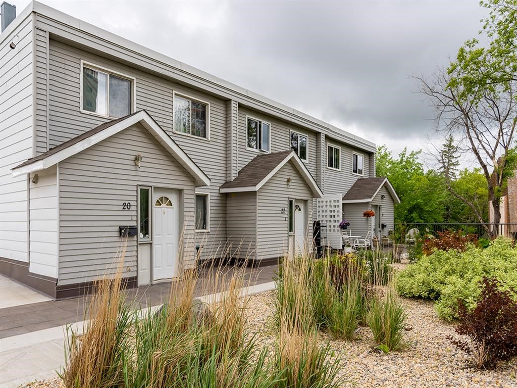the front of a gray house with a driveway and a porch