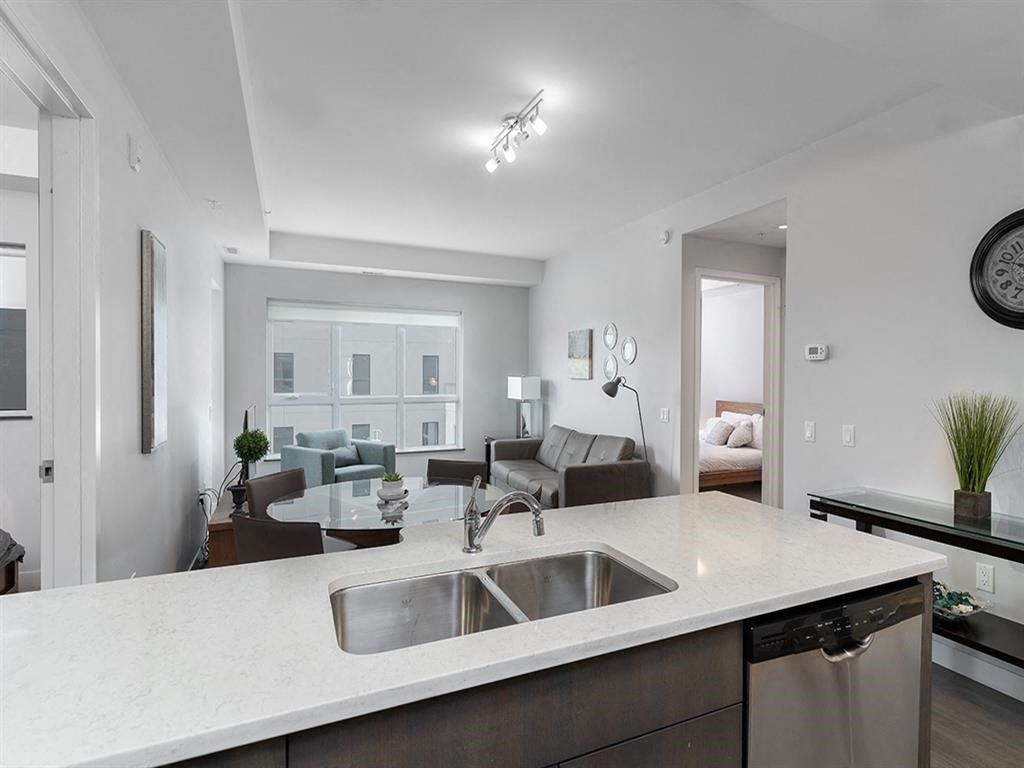 a kitchen with a sink and a view of a living room