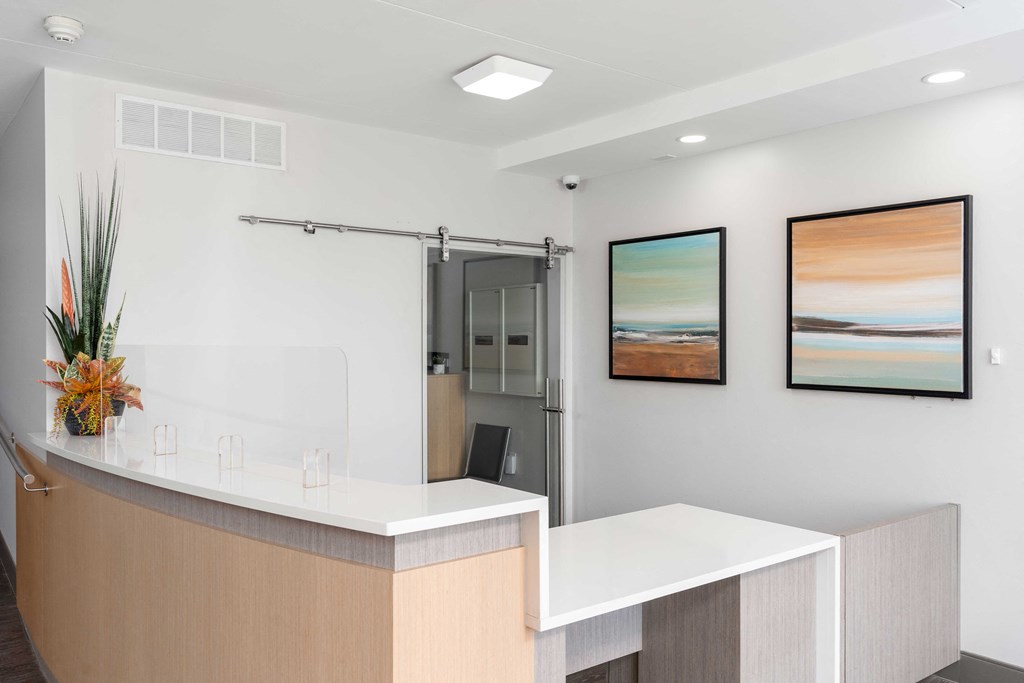 a modern reception desk with two paintings on the wall