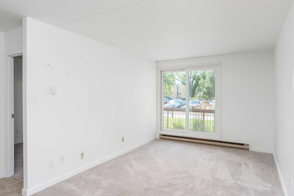 a bedroom with a large window and white walls