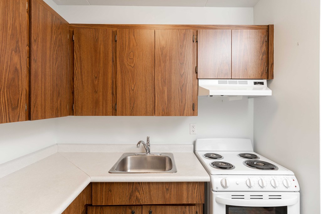 a kitchen with white appliances and wooden cabinets