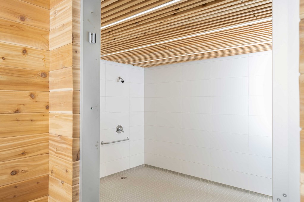 a bathroom with a wood paneled wall and a white tiled floor